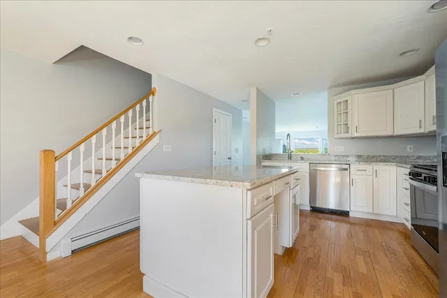 a kitchen with cabinets wooden floor and stainless steel appliances