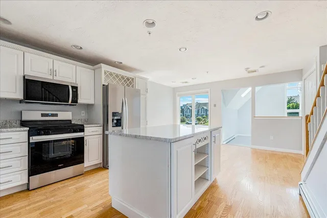 a kitchen with stainless steel appliances a stove top oven a sink and a refrigerator