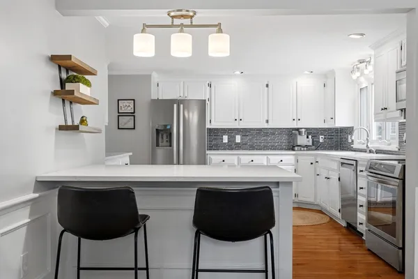 a kitchen with stainless steel appliances a stove a sink cabinets and a refrigerator