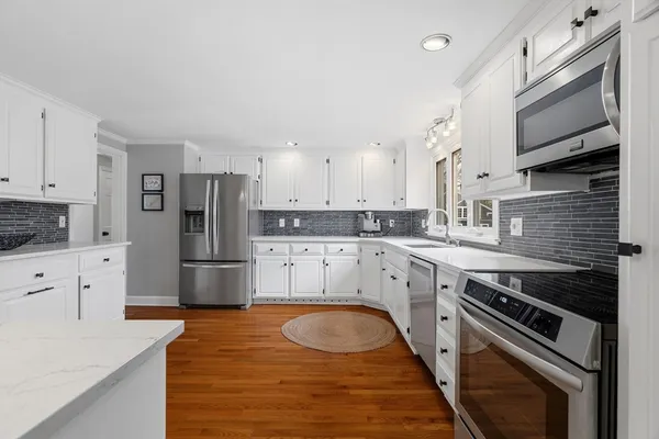 a kitchen with white cabinets and stainless steel appliances