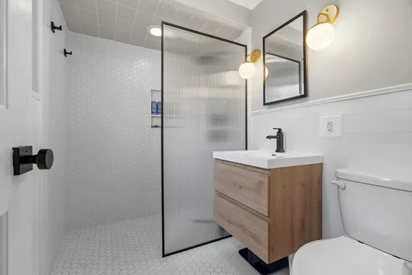 a bathroom with a sink a toilet and shower