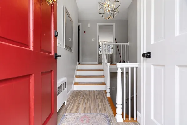 a view of a hallway with wooden floor and staircase