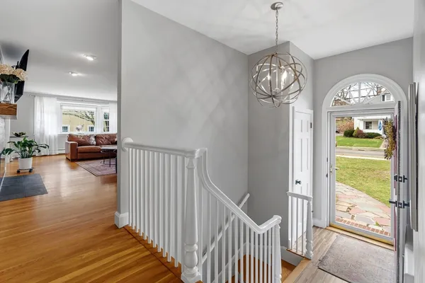 a view of a livingroom with furniture wooden floor windows and a chandelier