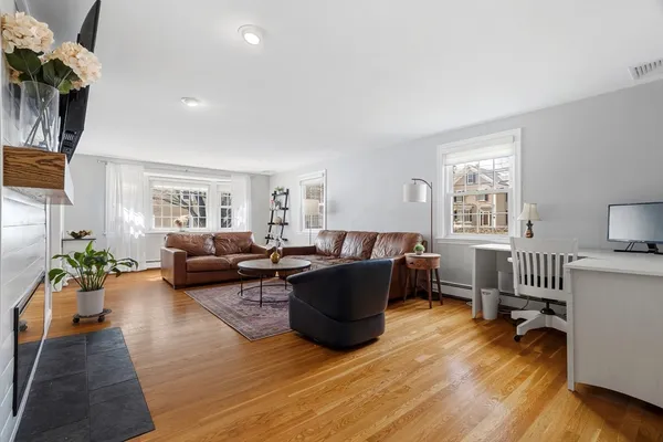a living room with furniture and a wooden floor