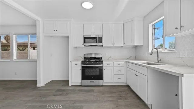 a kitchen with cabinets stainless steel appliances and a sink