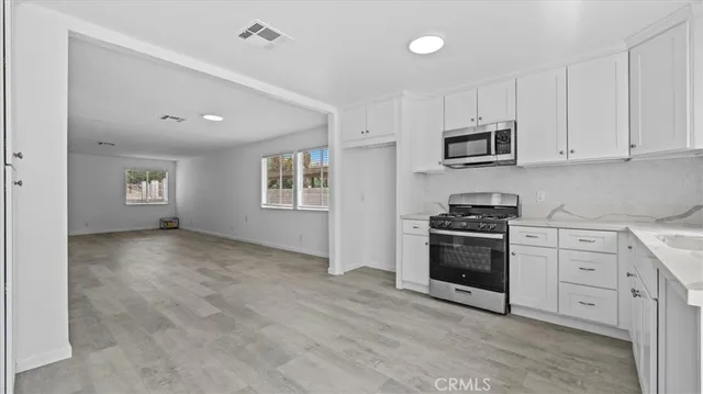 a kitchen with white cabinets and stainless steel appliances