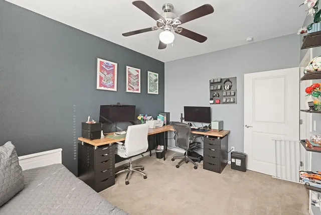 a view of a workspace with furniture and a window