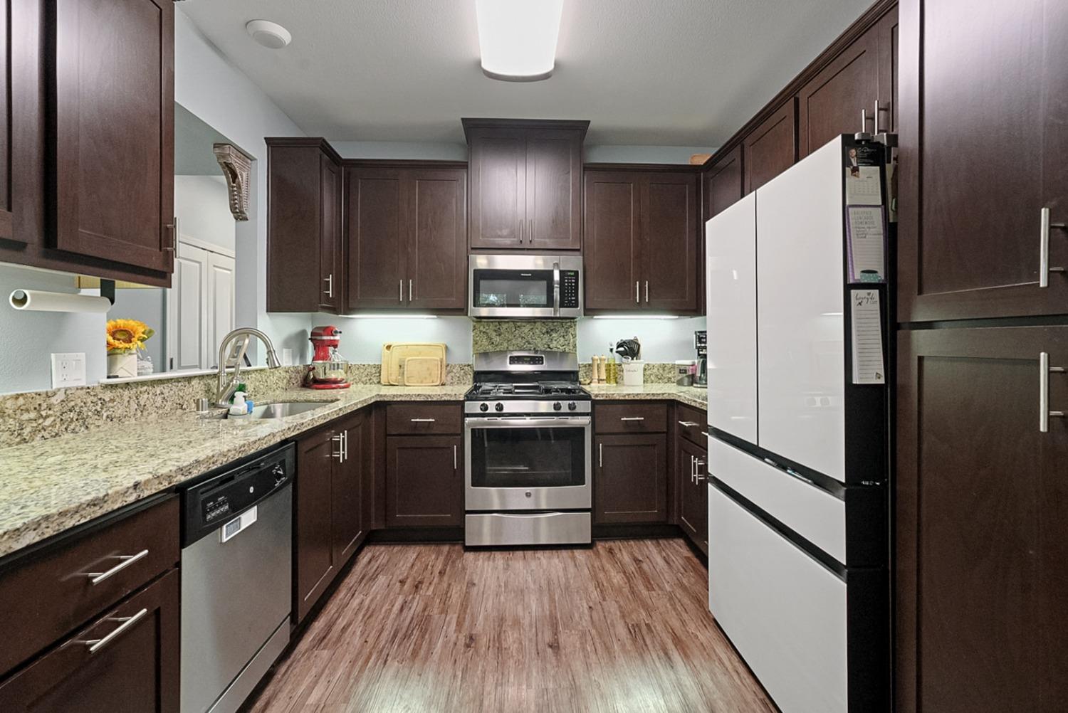 140 Ivy Avenue, Unit A5 Patterson, CA 95363 - Photo 7 of 26 a kitchen with granite countertop stainless steel appliances a sink and cabinets