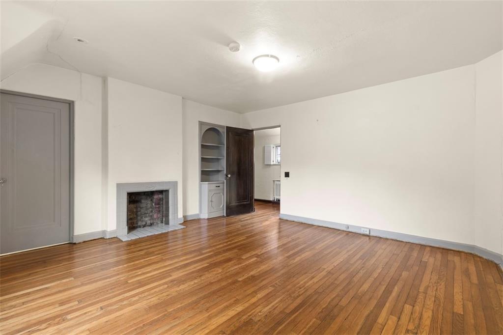 1 Robin Road Pittsburgh, PA 15217 - Photo 32 of 48 a view of an empty room with wooden floor fireplace and a window