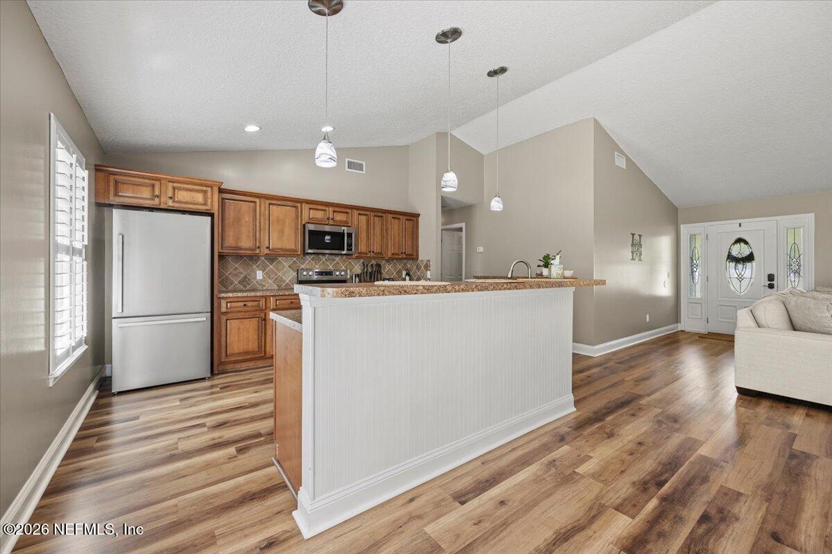 54130 Church Road Callahan, FL 32011 - Photo 11 of 42 a kitchen with stainless steel appliances kitchen island a refrigerator sink and cabinets