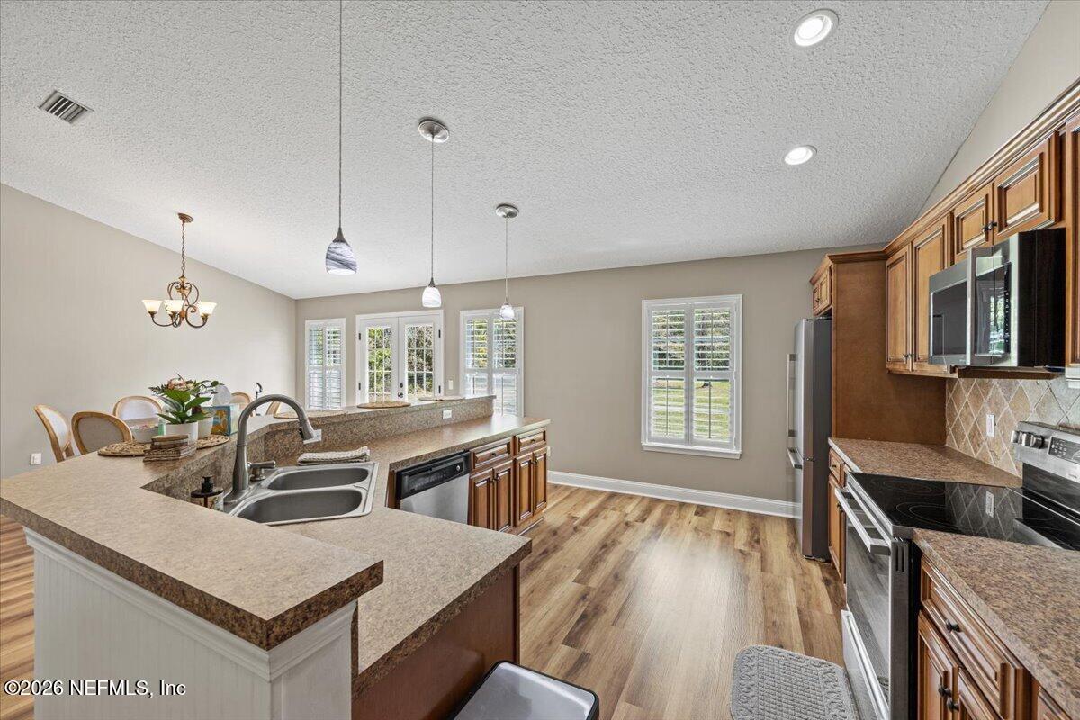 54130 Church Road Callahan, FL 32011 - Photo 14 of 42 a large kitchen with kitchen island a stove a sink a dining table and chairs
