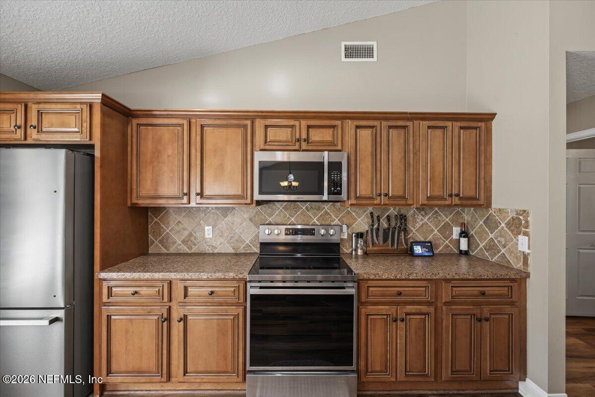 54130 Church Road Callahan, FL 32011 - Photo 16 of 42 a kitchen with granite countertop a stove oven and white cabinets