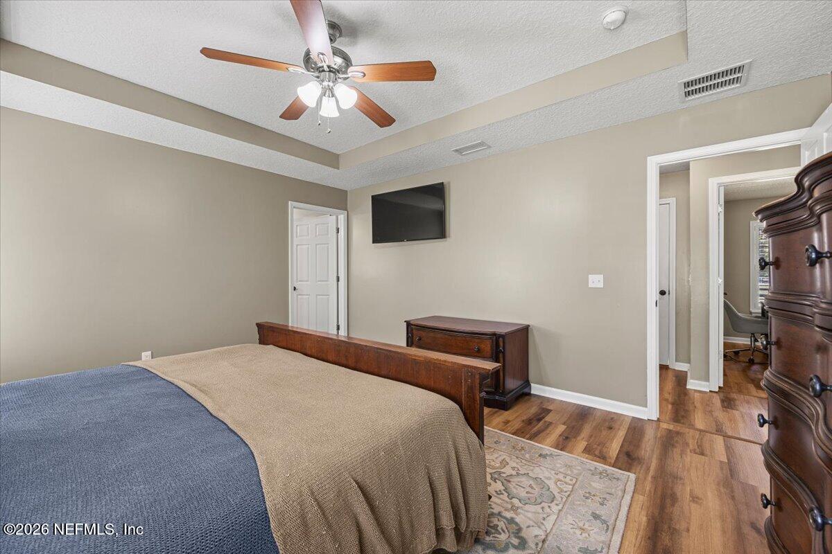 54130 Church Road Callahan, FL 32011 - Photo 23 of 42 a bedroom with a bed a flat screen tv and a chandelier