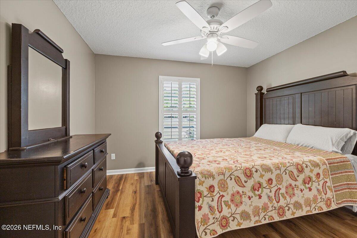 54130 Church Road Callahan, FL 32011 - Photo 32 of 42 a bedroom with a bed and a dresser with wooden floor