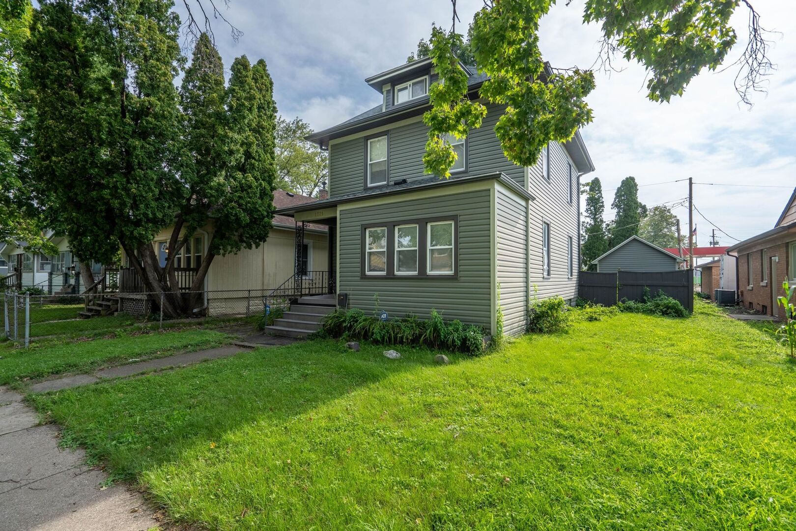 1721 28th Street Rock Island, IL 61201 - Photo 2 of 27 a view of a brick house with a big yard and large trees
