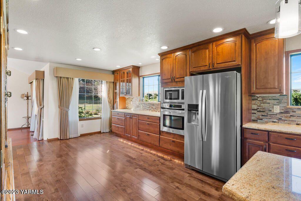 1703 Stein Road Yakima, WA 98908 - Photo 9 of 41 a kitchen with stainless steel appliances a refrigerator and a stove top oven
