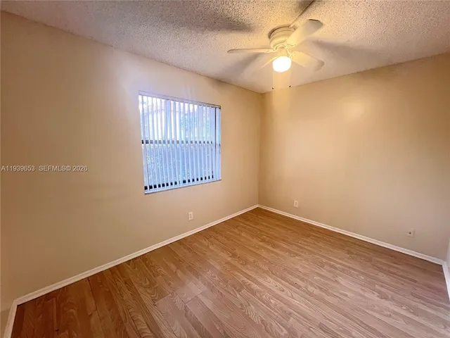 an empty room with a window and a ceiling fan