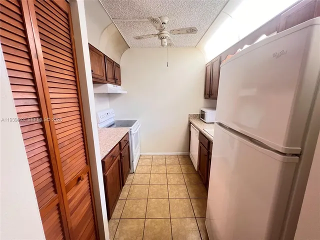 a kitchen with granite countertop a refrigerator and a stove