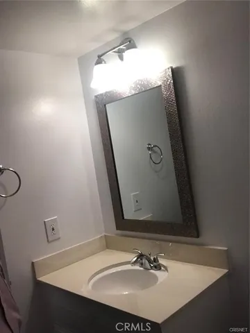 a kitchen with a sink a microwave a refrigerator and white cabinets