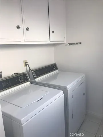 an empty room with wooden floor fireplace and windows