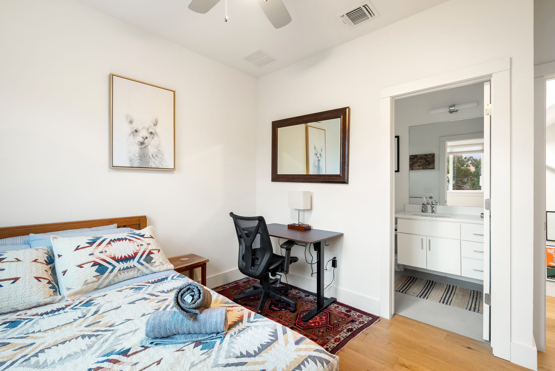 1709 Perez Street, Unit 2 Austin, TX 78721 - Photo 27 of 33 Well-lit sleeping quarters with rich hardwood flooring and convenient access to a modern bathroom.