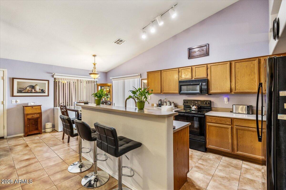 49 West Ivanhoe Street Gilbert, AZ 85233 - Photo 11 of 54 a kitchen with stainless steel appliances kitchen island granite countertop a stove top oven a sink a dining table and chairs with wooden floor