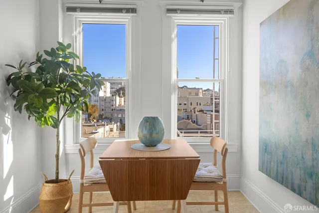 a dining room with furniture potted plants and wooden floor