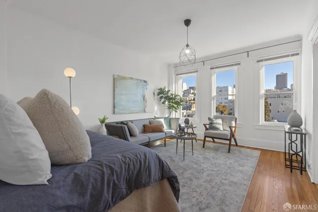 a living room with furniture and a wooden floor