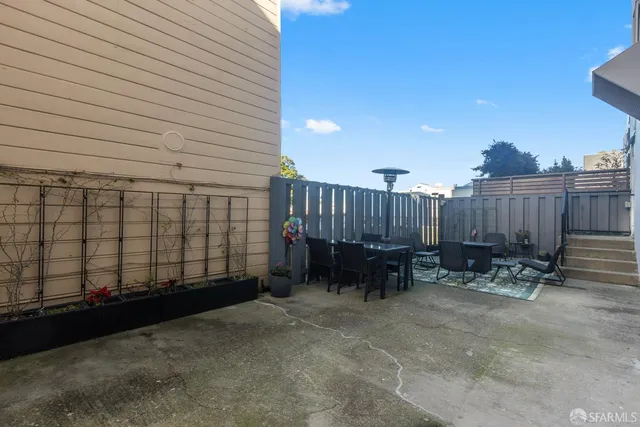 a backyard of a house with dining table and chairs