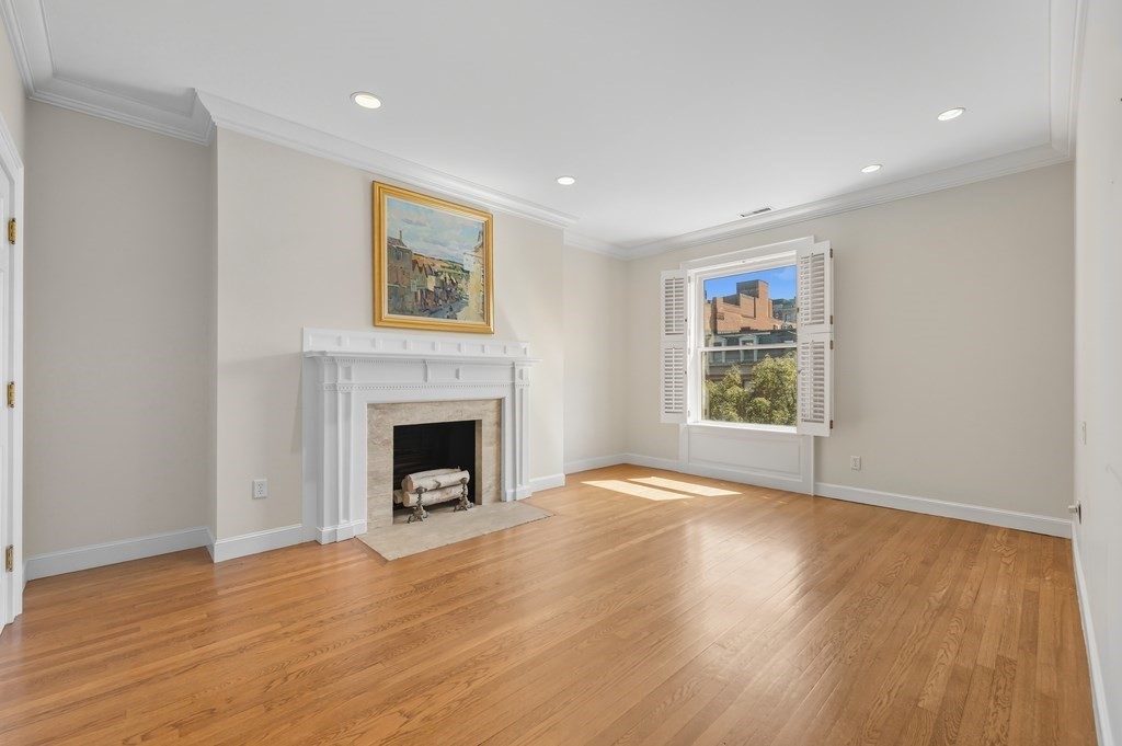 412 Beacon Street, Unit 6 Boston, MA 02115 - Photo 11 of 16 a view of a livingroom with a fireplace wooden floor and windows