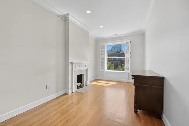 a view of empty room with a fireplace and wooden floor