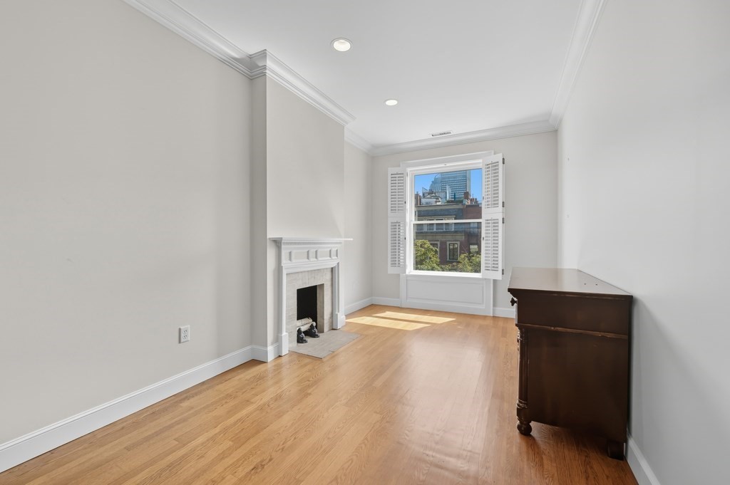 412 Beacon Street, Unit 6 Boston, MA 02115 - Photo 12 of 16 a view of empty room with a fireplace and wooden floor