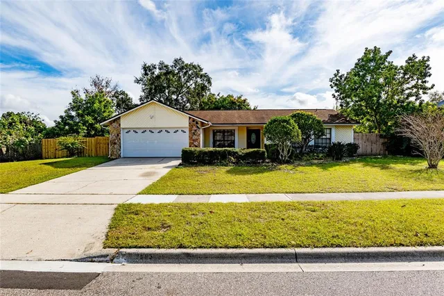 a view of house with swimming pool and a yard