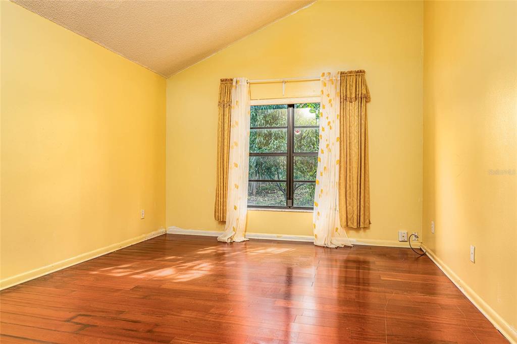 2903 Silver Ridge Drive Orlando, FL 32818 - Photo 13 of 27 a view of an empty room with wooden floor and a window