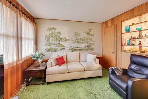 a bedroom with a bed and a dresser with mirror