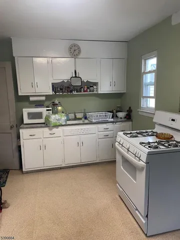 a kitchen with stainless steel appliances a white stove top oven sink and cabinets