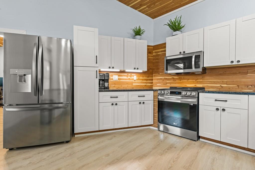 1129 Holly Road Gilmer, TX 75644 - Photo 4 of 31 Kitchen featuring wood-finish flooring and a wood plank backsplash