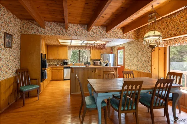 a dining room with furniture a chandelier and wooden floor