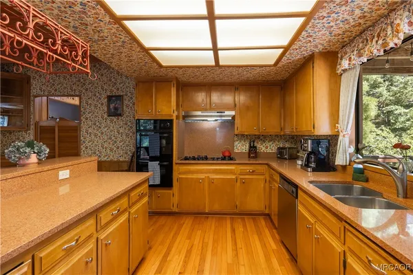 a kitchen with a sink a counter top space stainless steel appliances and cabinets