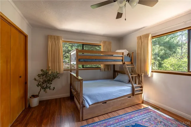 a living room with a bed and wooden floor