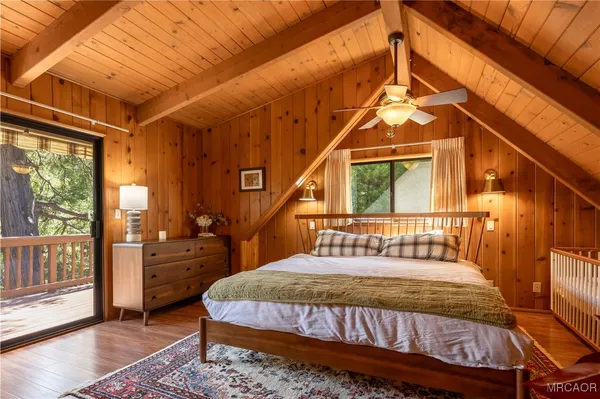 a bedroom with a bed a dresser next to a window