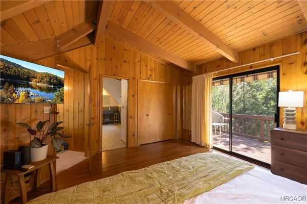 a spacious bedroom with a bed and wooden floor
