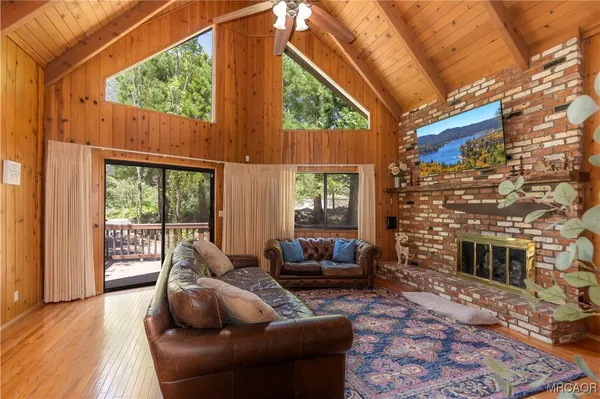 a living room with furniture a fireplace and a floor to ceiling window