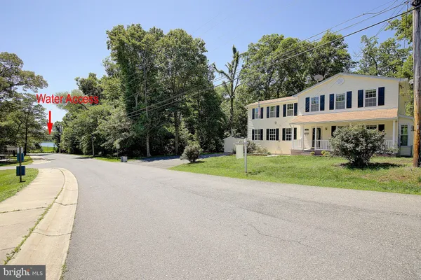 a view of house with yard and trees in the background