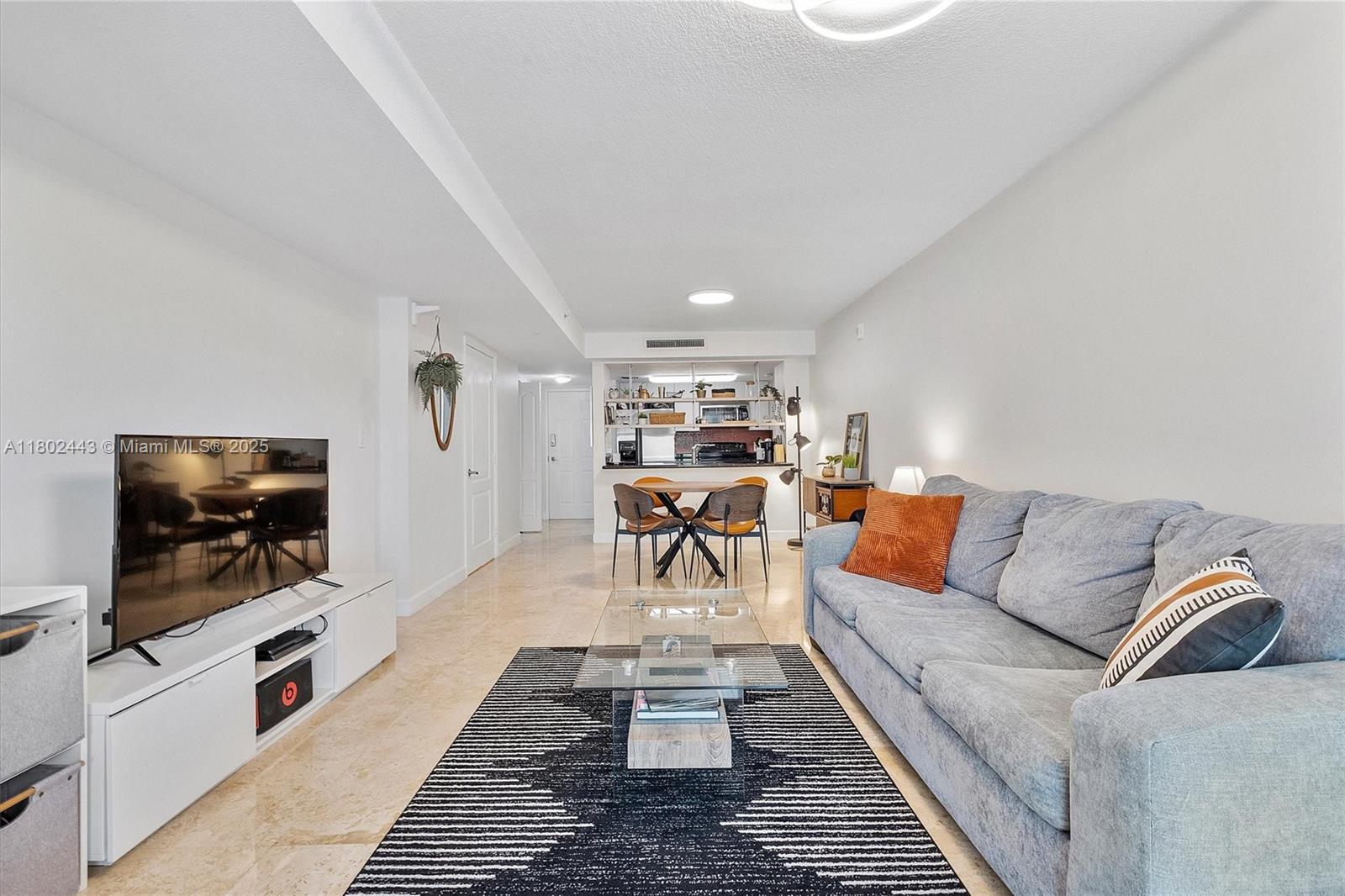 280 Southwest 20th Road, Unit 407 Miami, FL 33129 - Photo 2 of 23 a living room with furniture and a flat screen tv