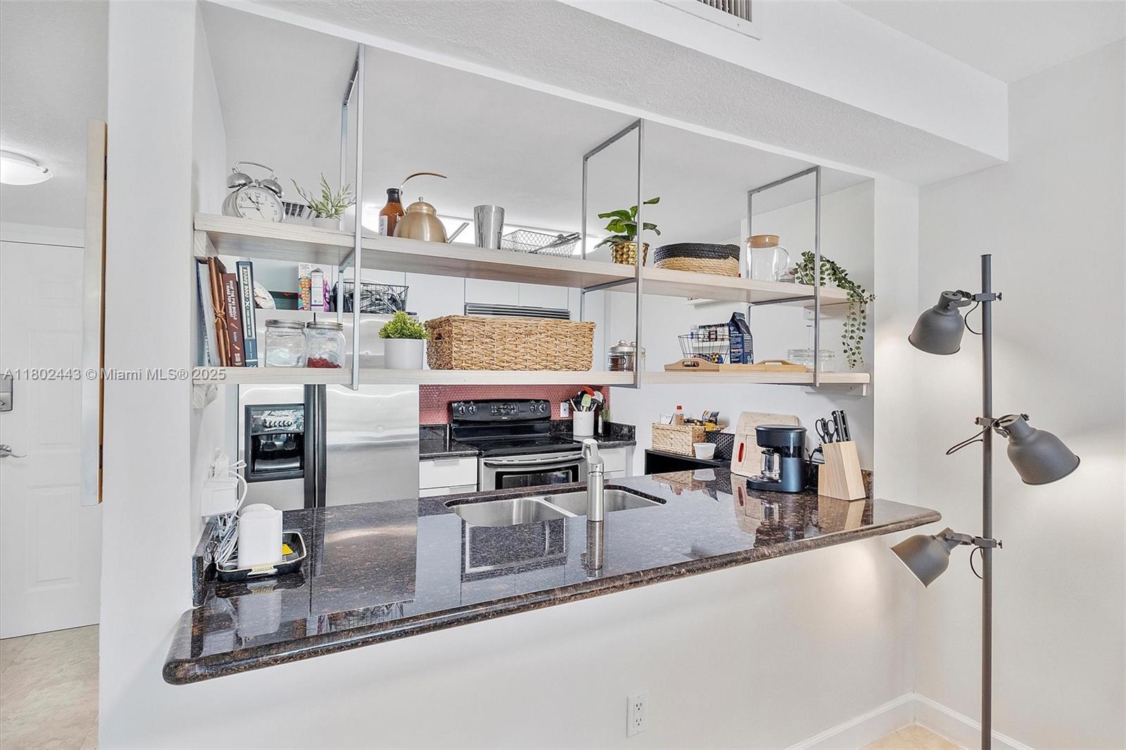 280 Southwest 20th Road, Unit 407 Miami, FL 33129 - Photo 4 of 23 a kitchen with stainless steel appliances granite countertop a sink and cabinets