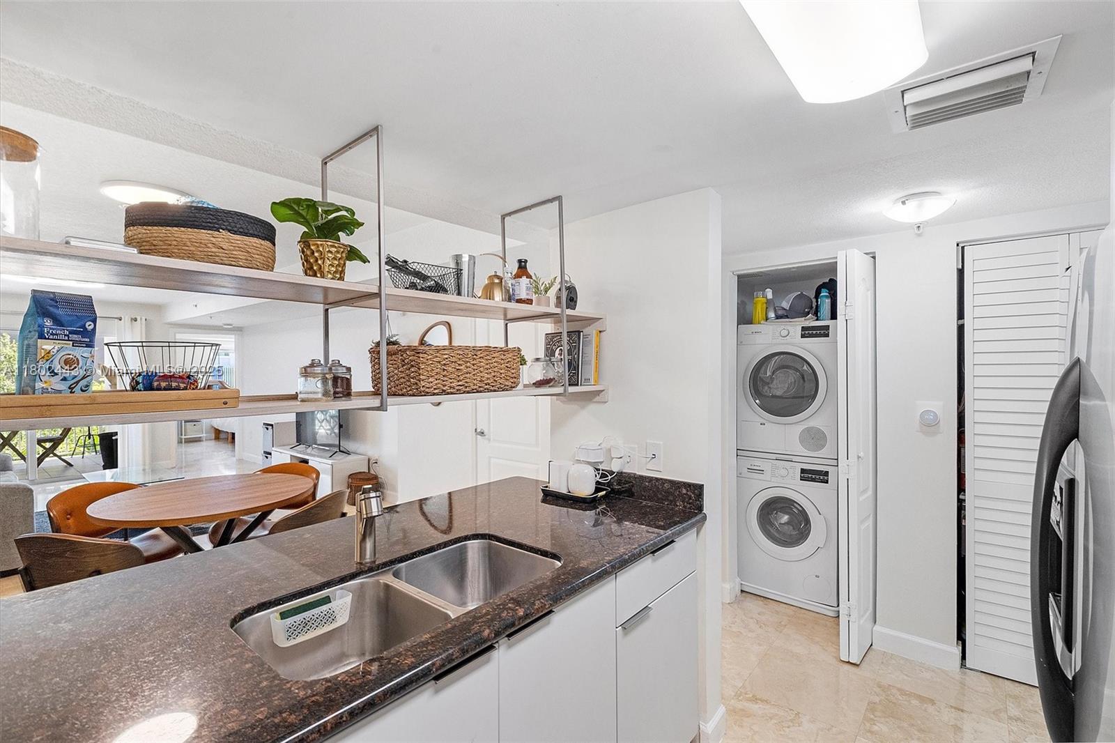 280 Southwest 20th Road, Unit 407 Miami, FL 33129 - Photo 6 of 23 a room with stainless steel appliances kitchen island granite countertop a sink and a refrigerator