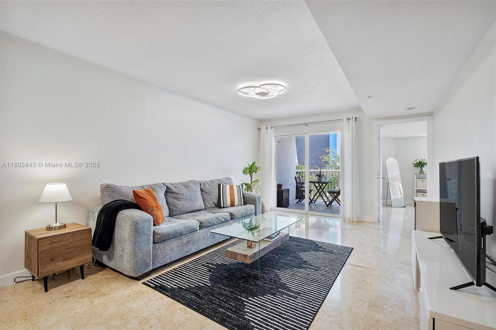 280 Southwest 20th Road, Unit 407 Miami, FL 33129 - Photo 8 of 23 a living room with furniture a rug and a flat screen tv