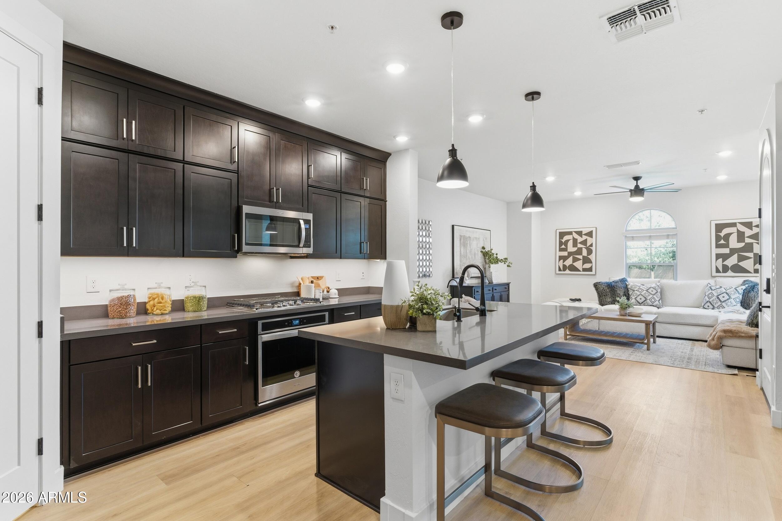 3855 South McQueen Road, Unit 34 Chandler, AZ 85286 - Photo 18 of 48 a kitchen with stainless steel appliances kitchen island granite countertop a sink and cabinets