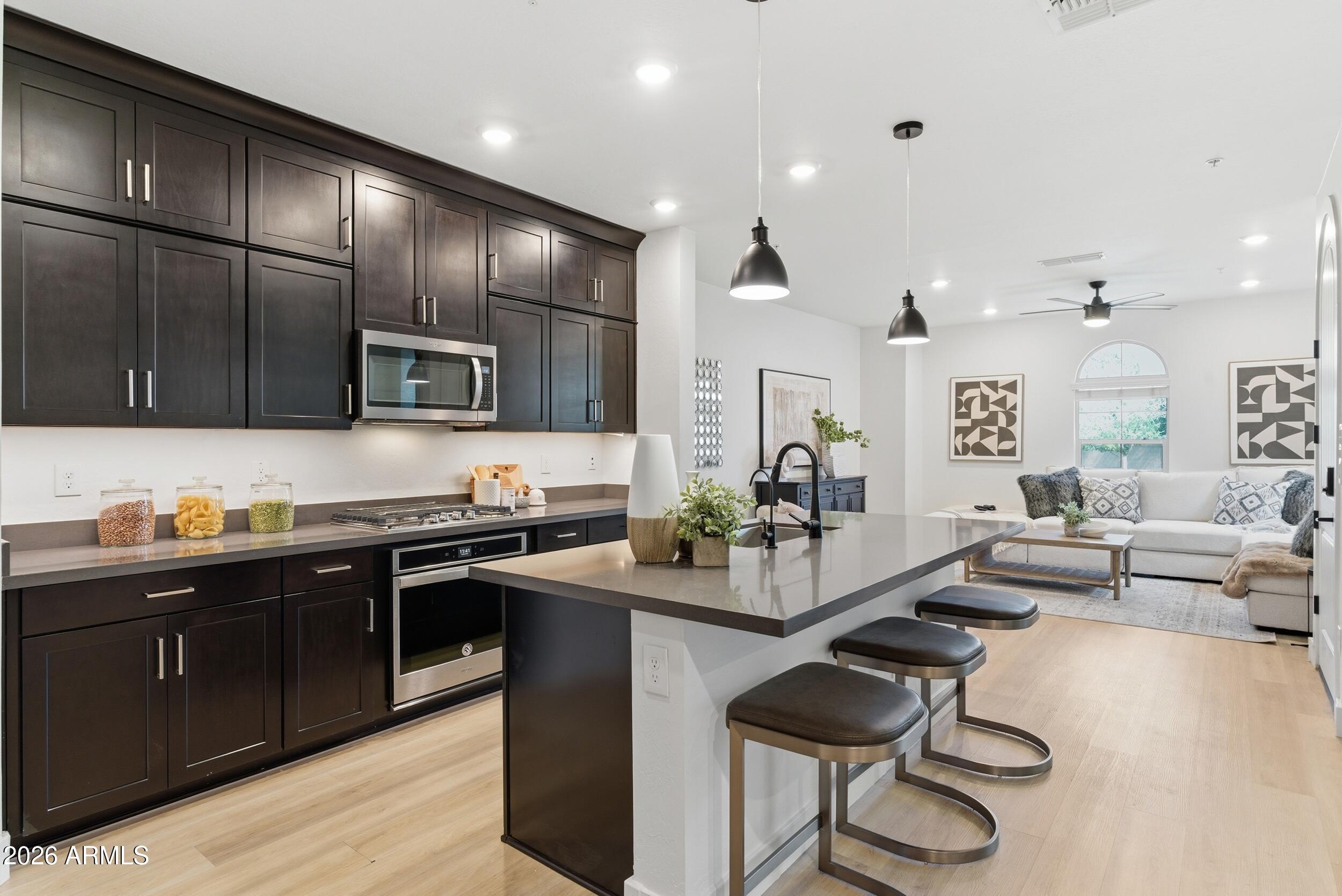3855 South McQueen Road, Unit 34 Chandler, AZ 85286 - Photo 19 of 48 a kitchen with stainless steel appliances kitchen island granite countertop a sink and cabinets
